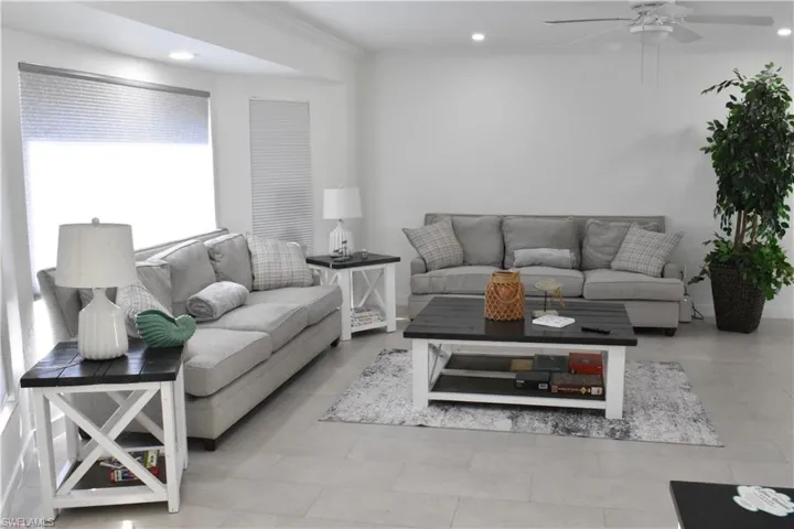 Living room with recessed lighting, ornamental molding, ceiling fan, and light tile patterned floors