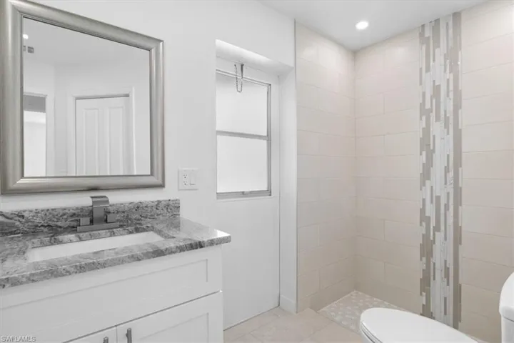 Bathroom with vanity, a stall shower, recessed lighting, and light tile patterned floors