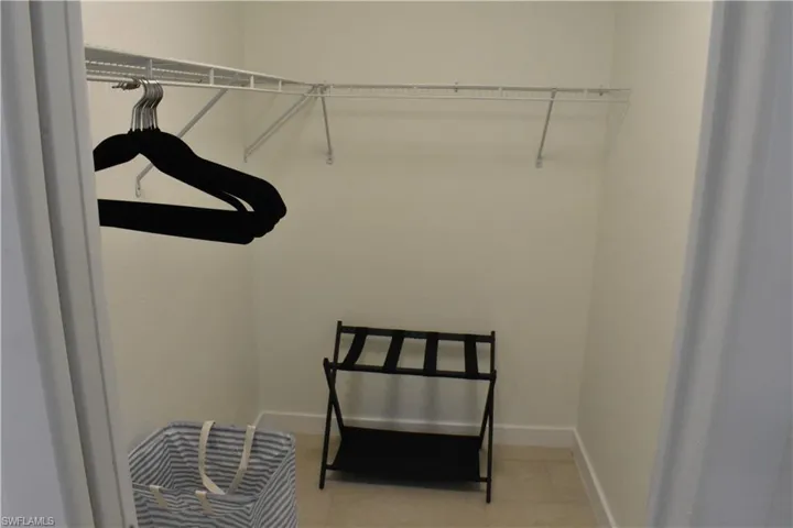 Walk in closet with light tile patterned floors