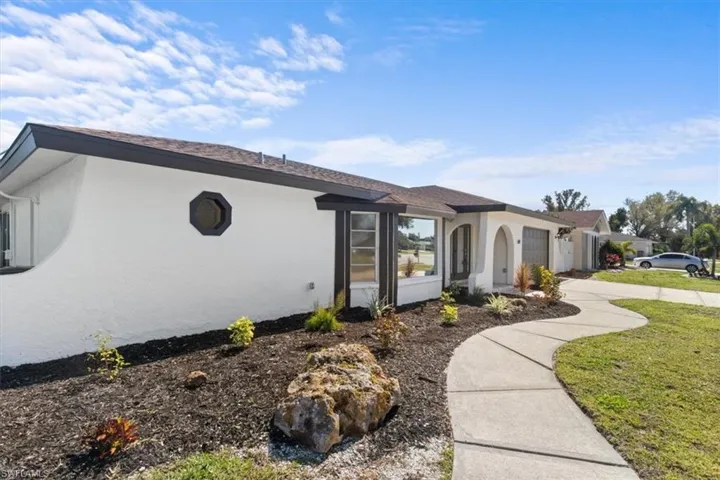 Single story home with stucco siding, driveway, a garage, and a front yard