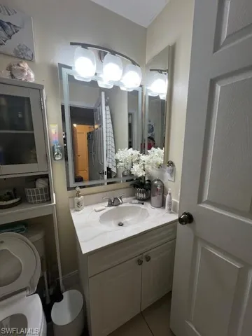 Half bath featuring vanity and light tile patterned floors