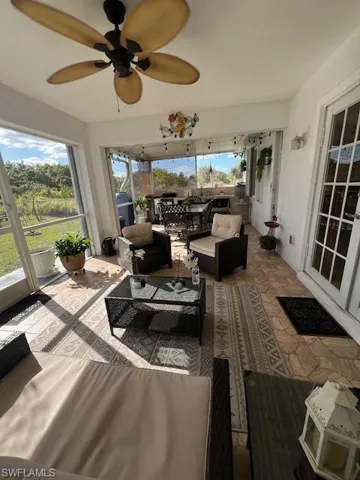 Sunroom with ceiling fan and an outdoor living space