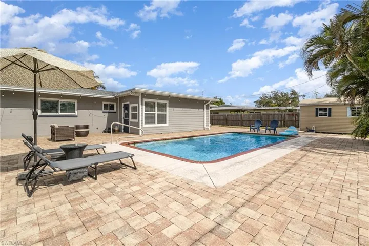 View of swimming pool with a patio and a storage unit