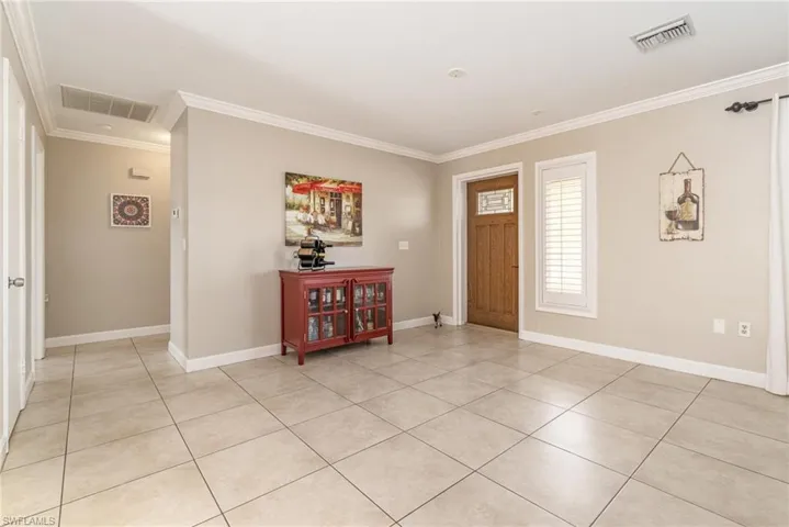 Foyer featuring ornamental molding and light tile patterned flooring
