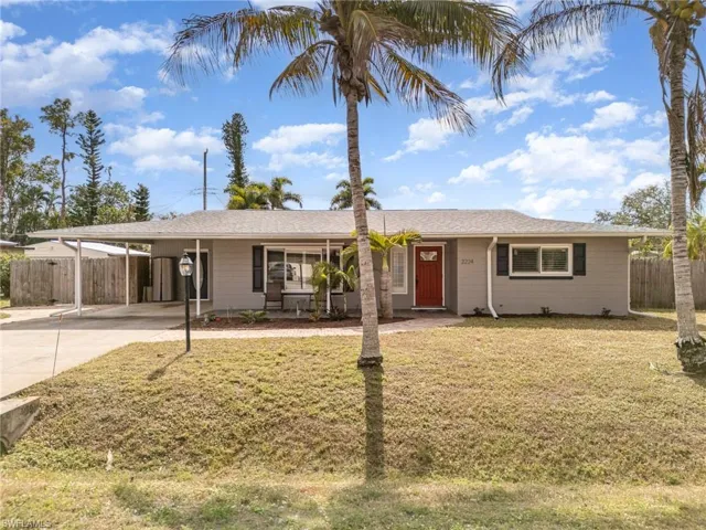 Ranch-style house with a carport and a front yard