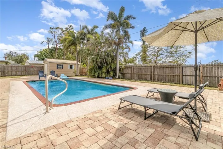 View of swimming pool with a patio and a storage unit