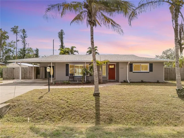 Single story home featuring a carport and a lawn