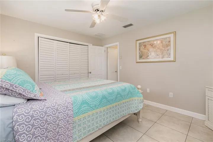 Tiled bedroom with a closet and ceiling fan