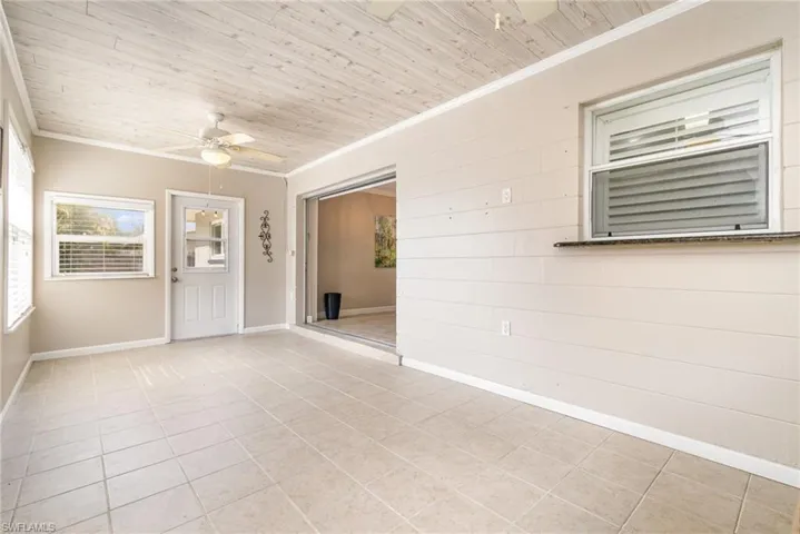 Tiled spare room - Florida Room/Den featuring wood ceiling, ceiling fan, and ornamental molding