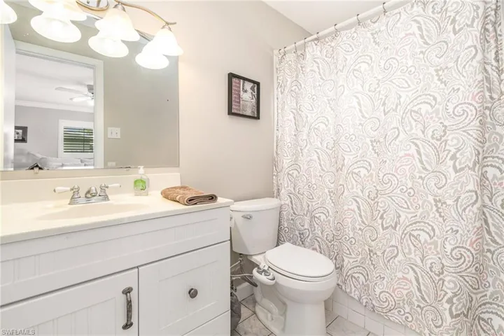 Bathroom featuring vanity, ornamental molding, ceiling fan, toilet, and tile patterned floors