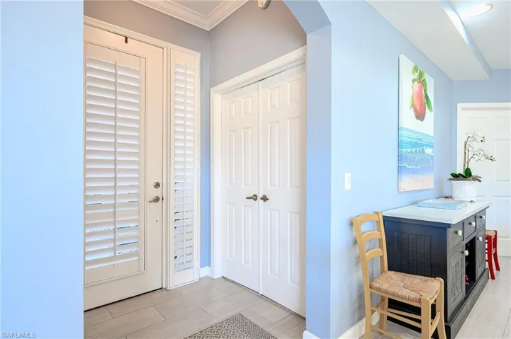 Foyer featuring arched walkways, wood style ceramic tile floors, and gorgeous crown molding