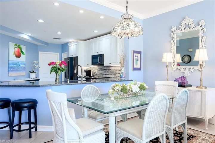 Dining area featuring light ceramic wood finished tile floors, recessed lighting, crown molding, and a chandelier