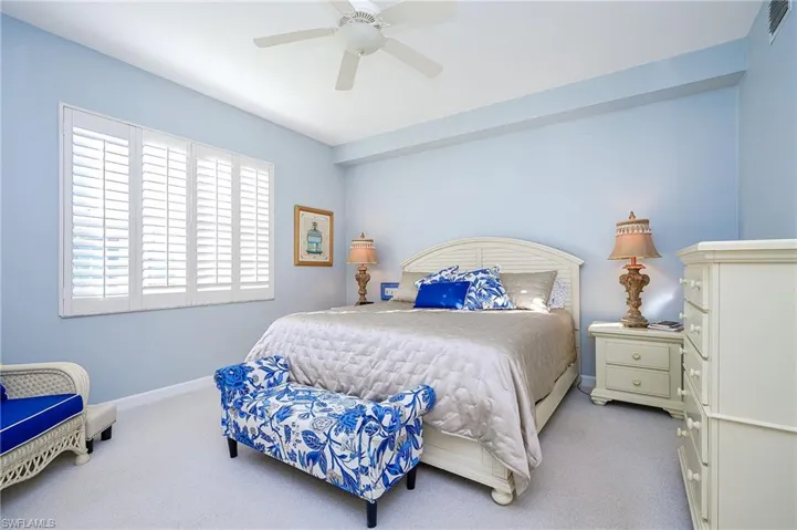 Spacious Master suite with wood shutters and plush carpeting