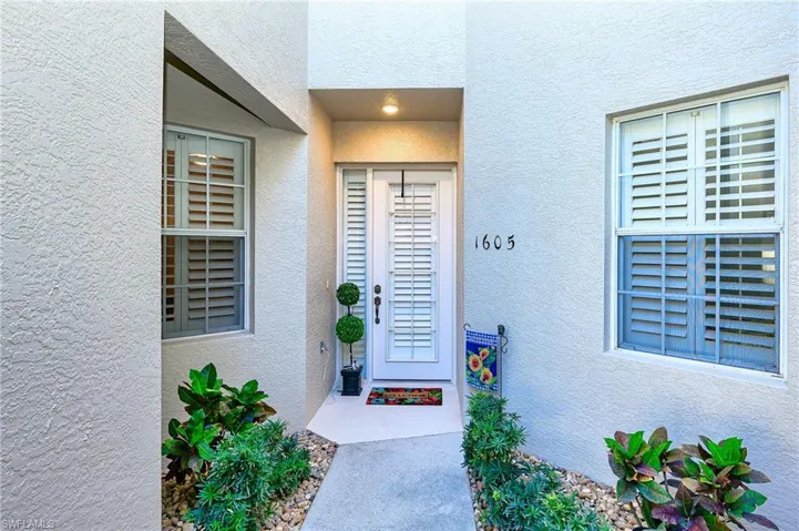 Doorway to property featuring stucco siding