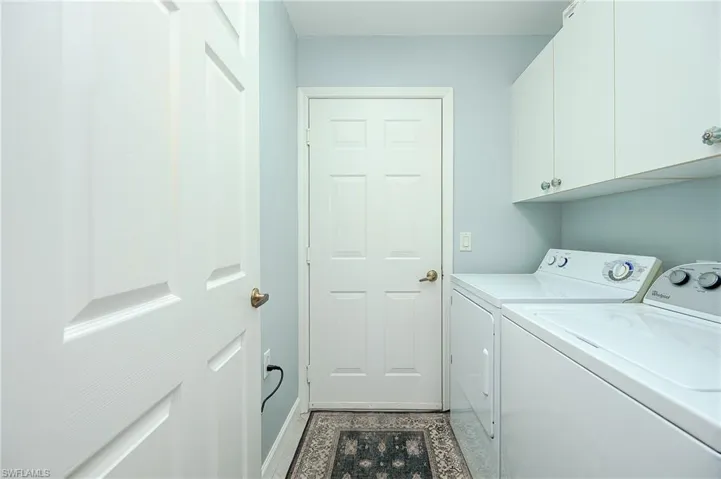 Washroom featuring independent washer and dryer and cabinet space