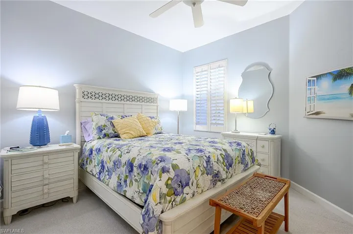 Spacious Carpeted bedroom with ceiling fan and beautiful wood shutters
