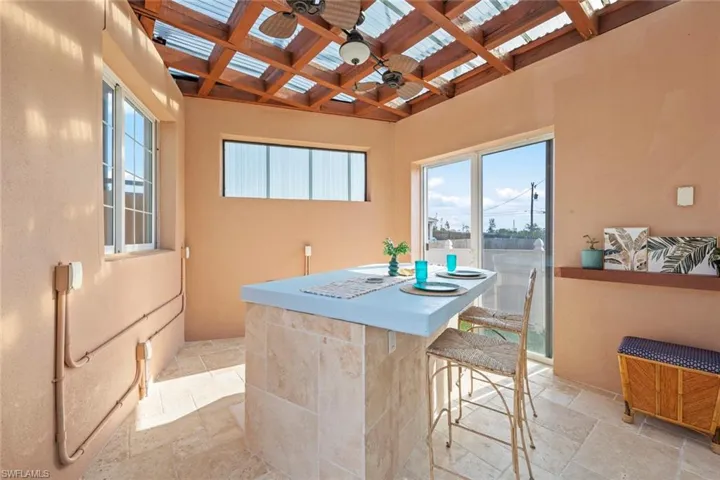 View of patio with ceiling fan and outdoor dry bar