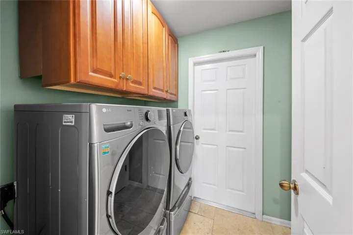 Laundry room featuring washer and clothes dryer, baseboards, and cabinet space