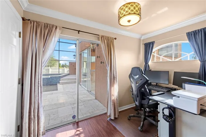 Office with baseboards, crown molding, and wood finished floors