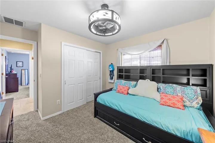 Carpeted bedroom with baseboards and a closet