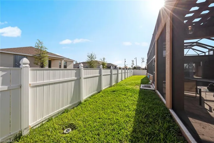 View of yard featuring a fenced backyard and glass enclosure