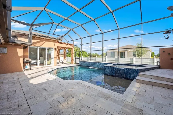 View of swimming pool with a patio area, a pool with connected hot tub, a fenced backyard, and a lanai