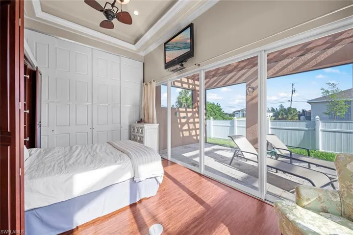 Bedroom featuring multiple windows, access to outside, and wood finished floors