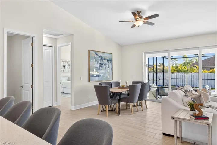 Dining area with wood tiled floors, a ceiling fan, and lofted ceiling