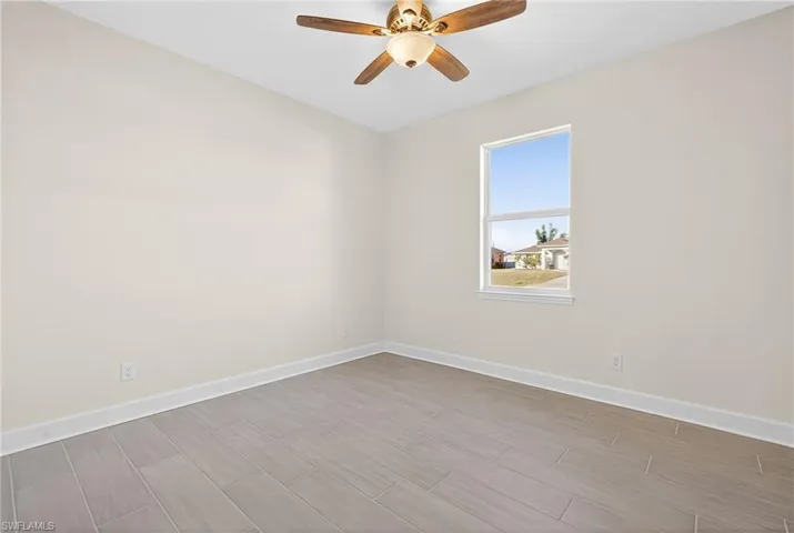 Unfurnished room with wood finish floors and ceiling fan