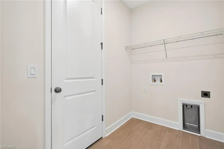 Laundry room featuring hookup for an electric dryer, hookup for a washing machine, and wood tiled floors