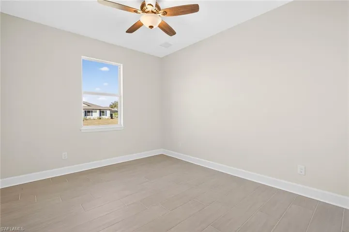 Spare room with wood finish floors and ceiling fan