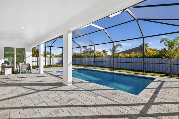 View of pool with a sunroom, glass enclosure, a patio, and a fenced backyard