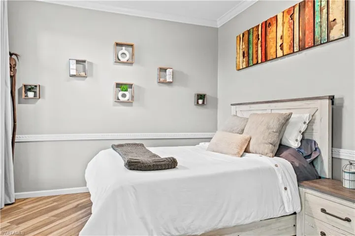 Bedroom featuring ornamental molding and wood finished floors