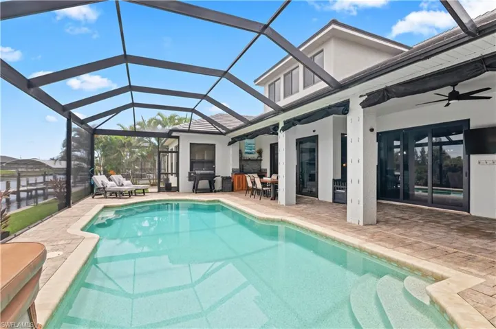 Swimming pool featuring a lanai, a patio area, a sunroom, french doors, and outdoor dining area