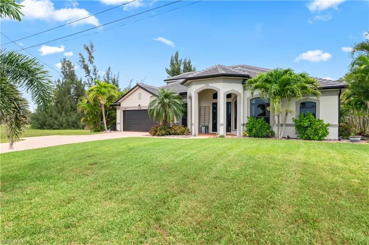 Mediterranean / spanish-style house with concrete driveway, stucco siding, a front yard, and an attached garage