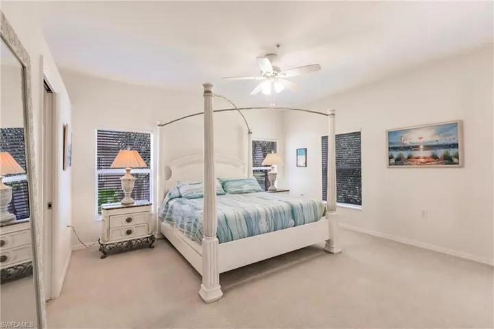 Bedroom with ceiling fan and light carpet