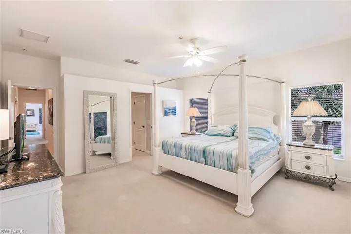 Bedroom with light colored carpet and a ceiling fan