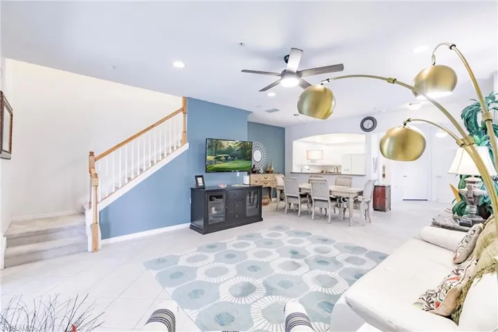 Living room featuring ceiling fan, arched walkways, recessed lighting, and light tile patterned floors