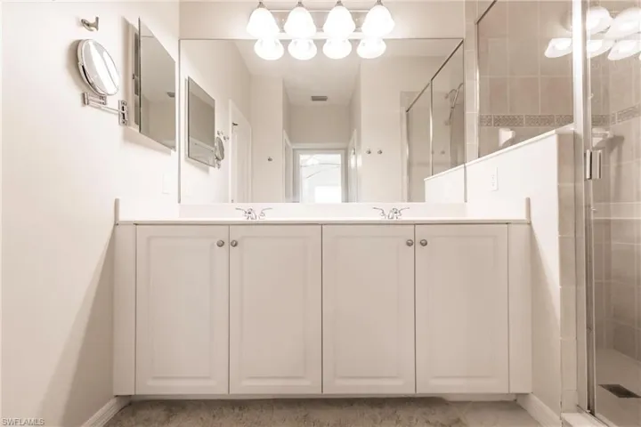 Full bathroom with a shower stall and double vanity