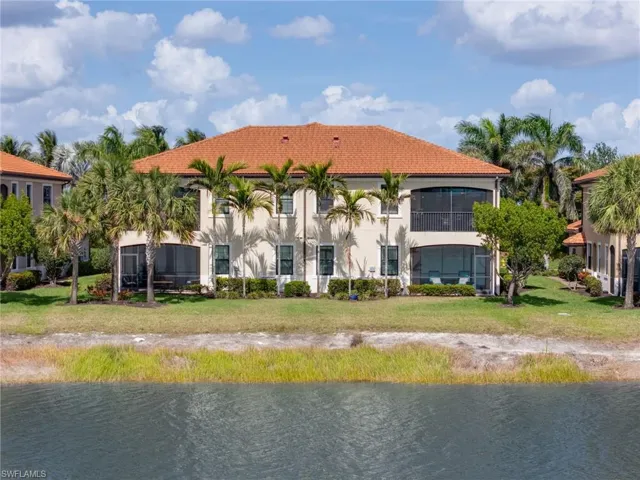 Rear view of property with a tiled roof, a water view, and stucco siding