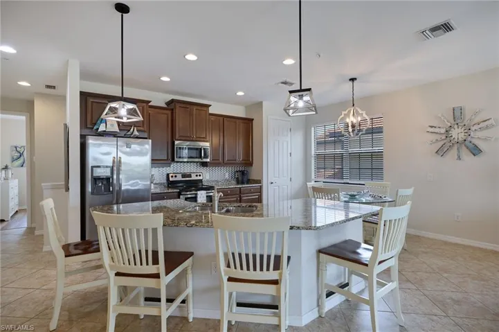 Kitchen with backsplash, a sink, appliances with stainless steel finishes, and visible vents