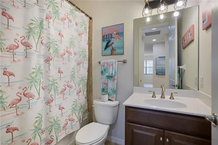 Full bathroom featuring toilet, vanity, and visible vents