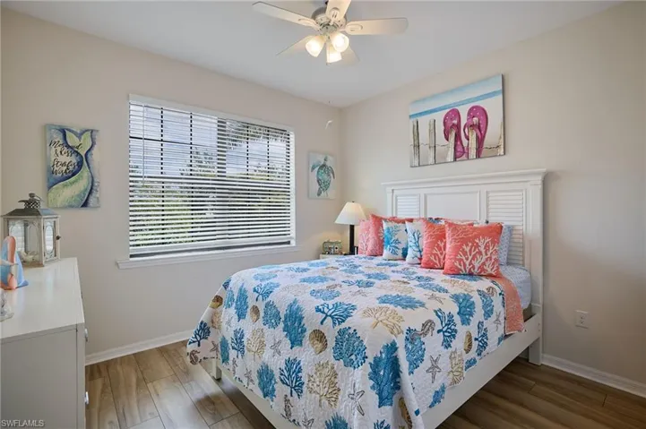 Bedroom with baseboards, wood finished floors, and ceiling fan