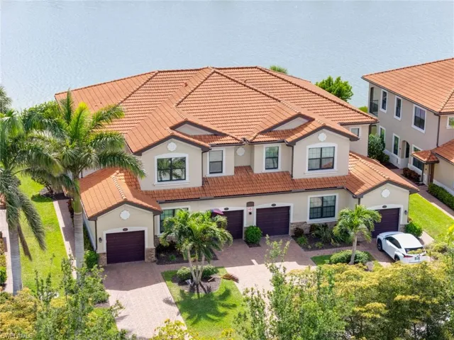 Mediterranean / spanish-style home featuring stone siding, a tile roof, stucco siding, and decorative driveway