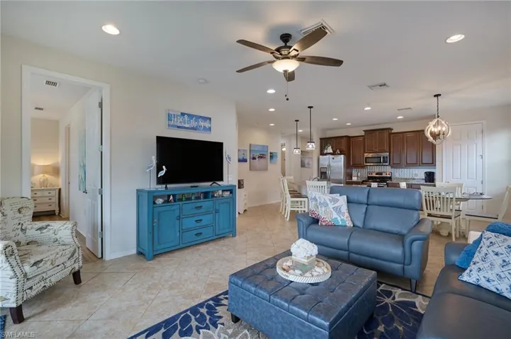 Living area with visible vents, recessed lighting, and ceiling fan with notable chandelier