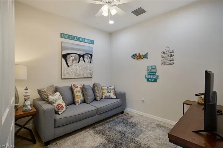 Living area with a ceiling fan, baseboards, and visible vents