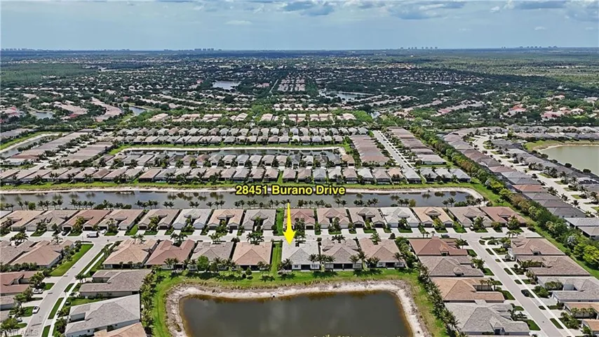 Aerial perspective showcasing a residential community with numerous properties featuring tile roofs and paved driveways