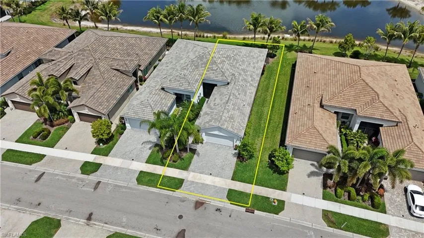 Single-story residence featuring a tile roof, paved driveway, and established landscaping