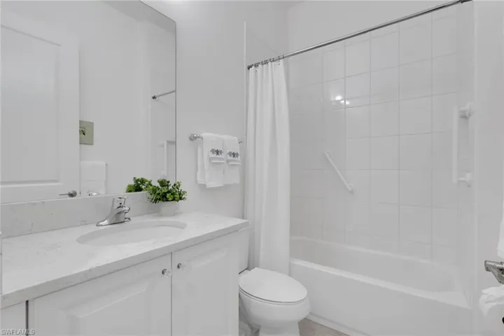 Modern bathroom featuring a single vanity with a light-colored countertop, an integrated sink, and white cabinetry