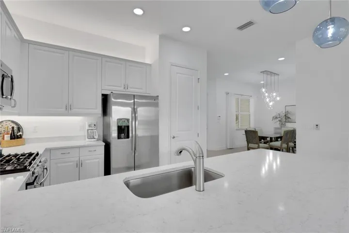 Kitchen featuring stainless steel appliances, light gray cabinetry, and light-toned countertops